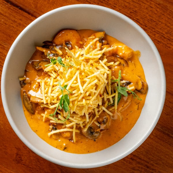 Creamy mushroom and shrimp stroganoff topped with crispy shoestring fries and fresh herbs.